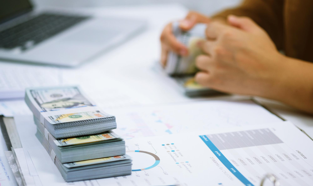 Money being stacked over data sheets